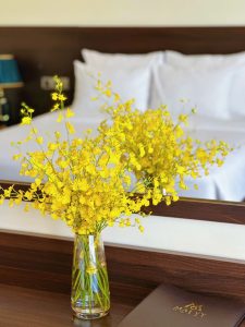 Bình hoa vàng trong phòng ngủ tại Mai Vy Hotel Tây Ninh vào mùa hè